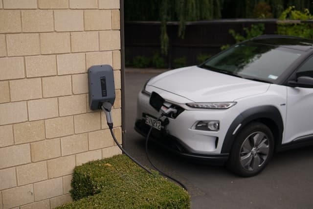 a white electric car at home charging
